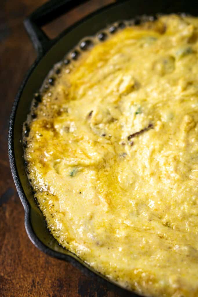 The cornbread batter in a cast-iron skillet before going in the oven