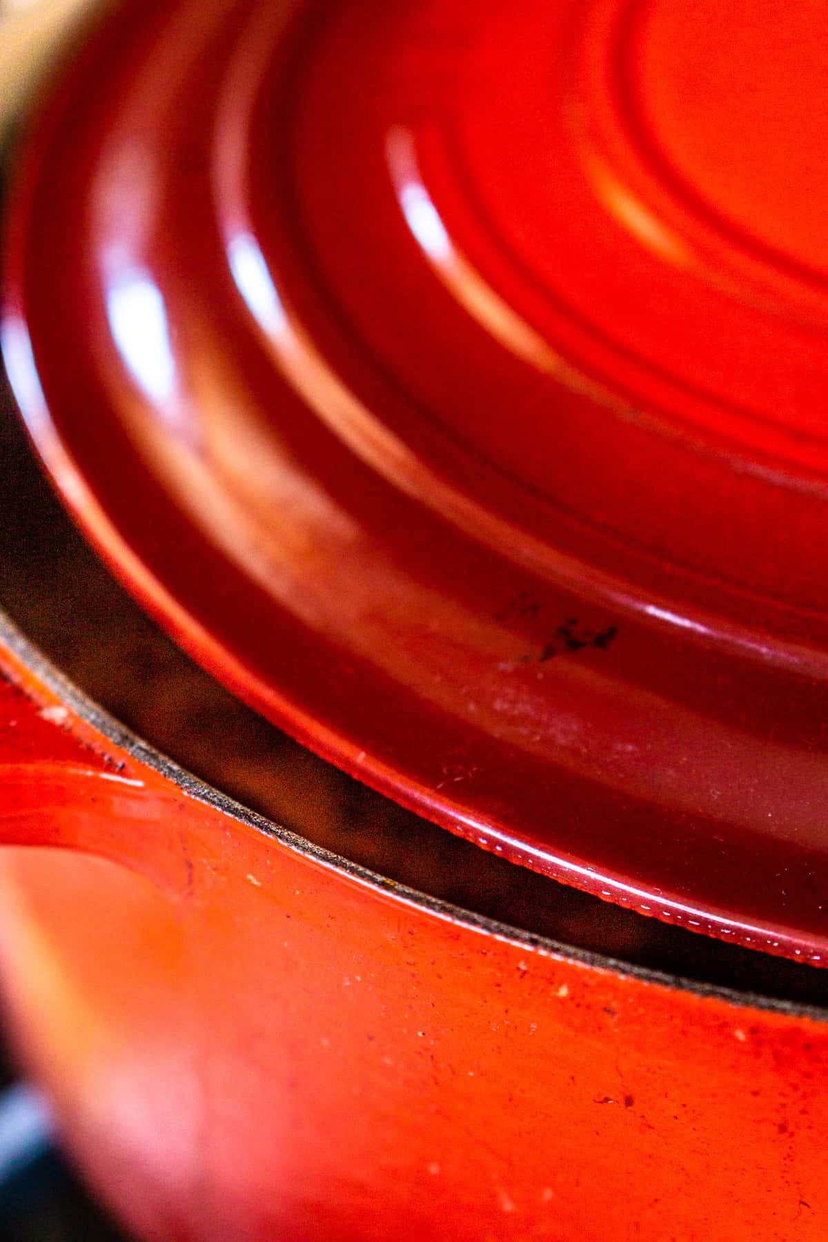 The chili cooking in a Dutch oven with the lid barely cracked open.