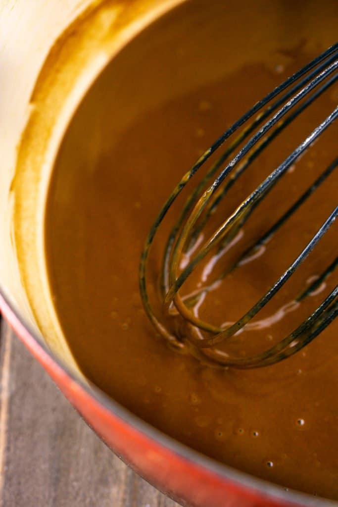 A Dutch oven filled with chocolate-colored oven roux.