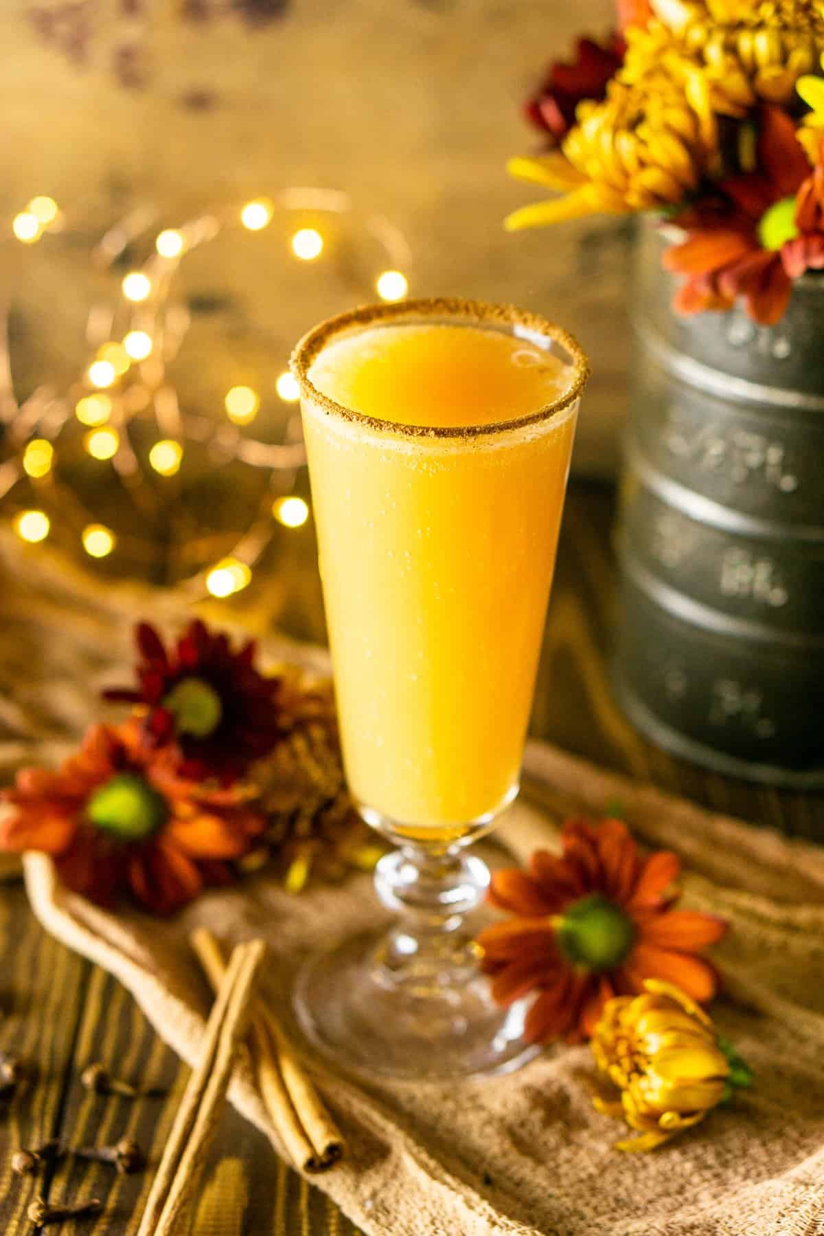One autumn brunch cocktail with fall flowers around it.