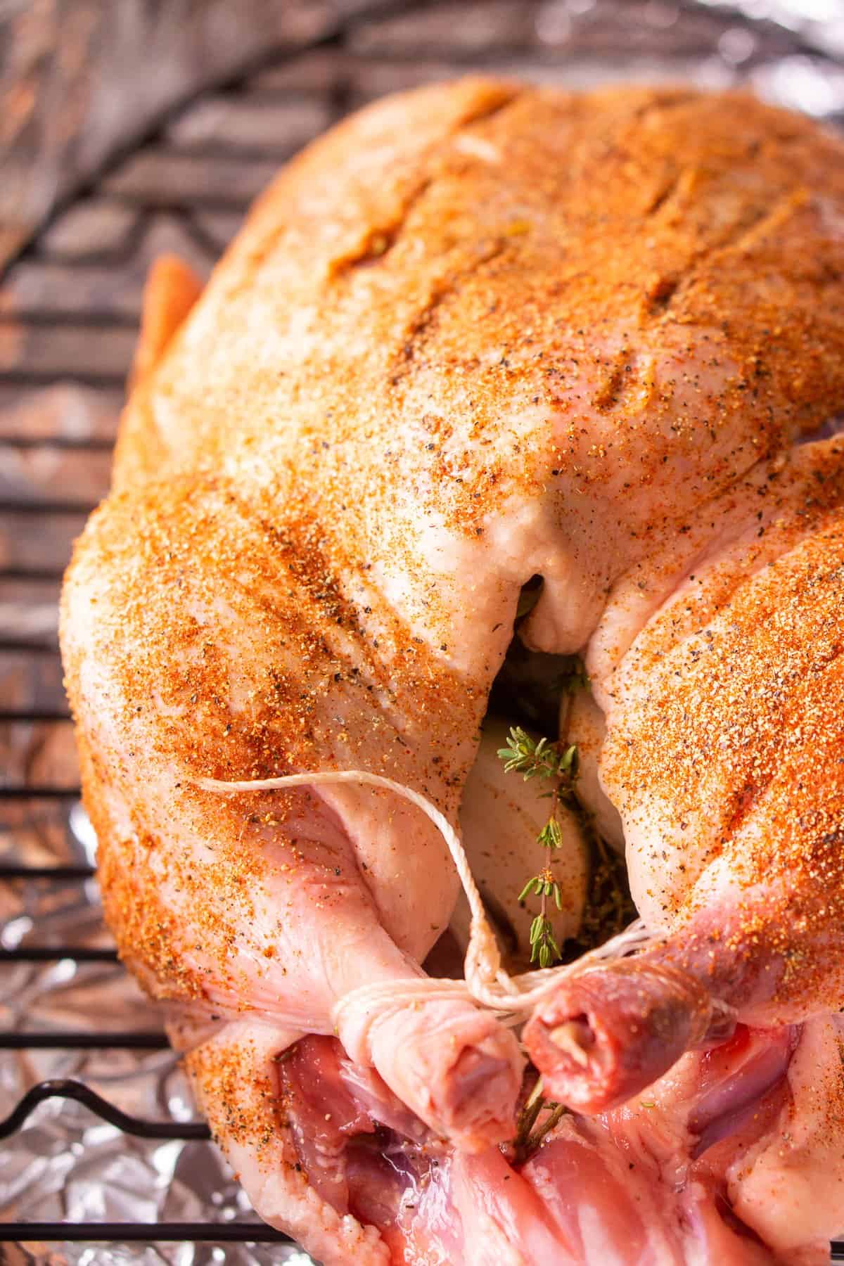 The duck seasoned on a roasting pan ready to go in the oven.