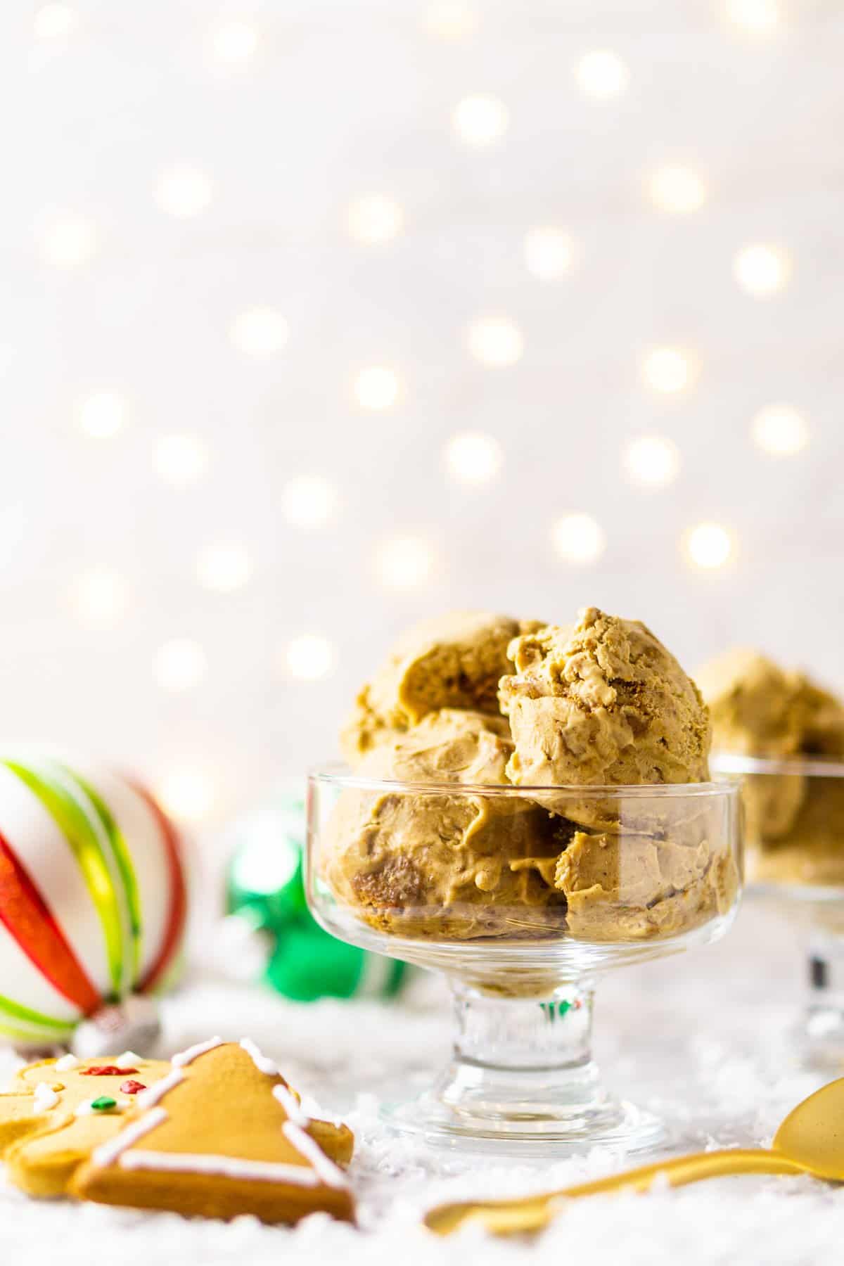 A close-up shot of the gingerbread ice cream with ornaments behind it on a white backdrop.