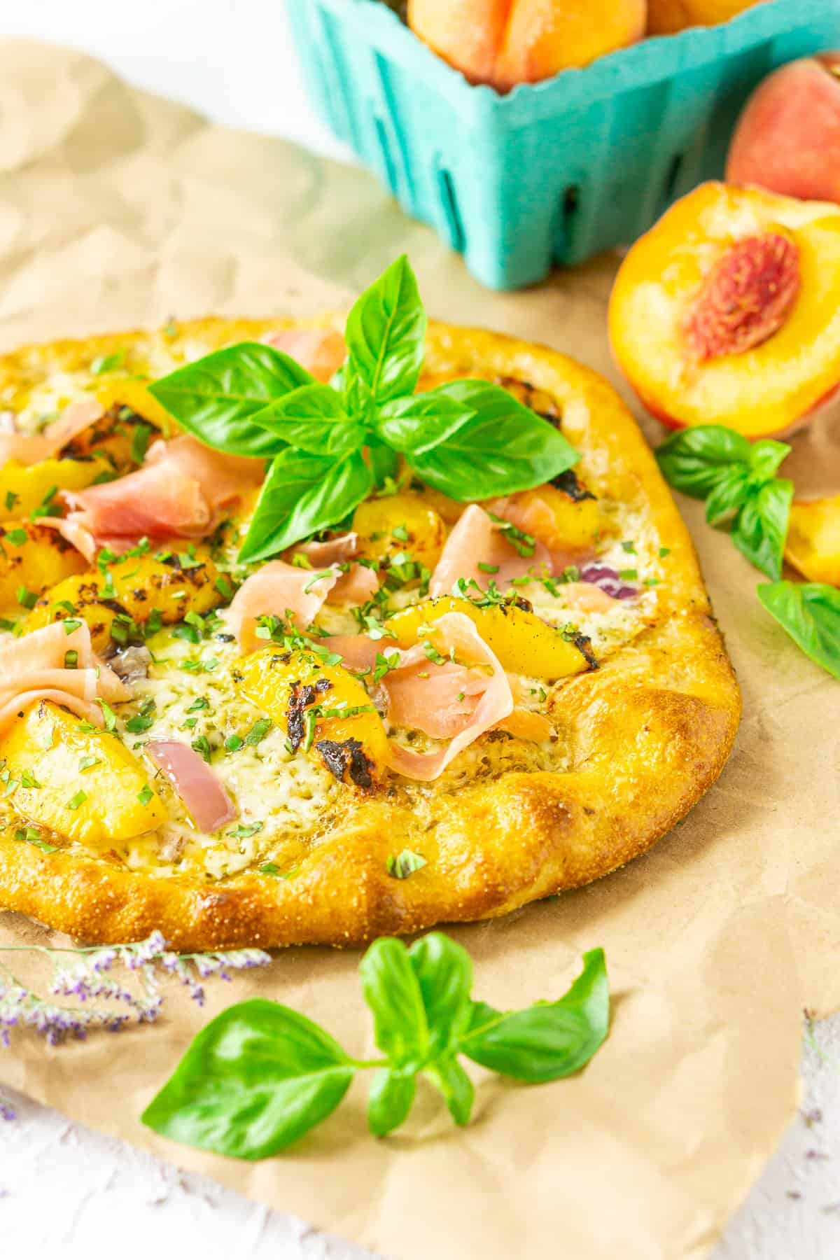 Looking down on the grilled peach pizza on parchment paper.