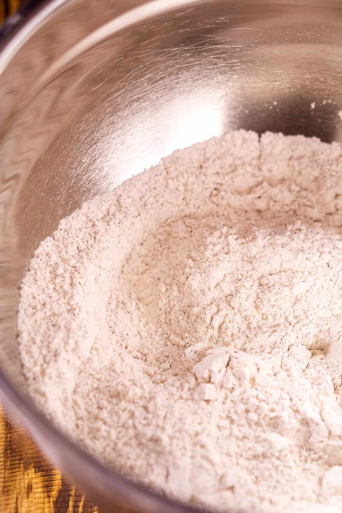 A mixing bowl with the flour, baking soda, salt and espresso powder after they have all been combined.