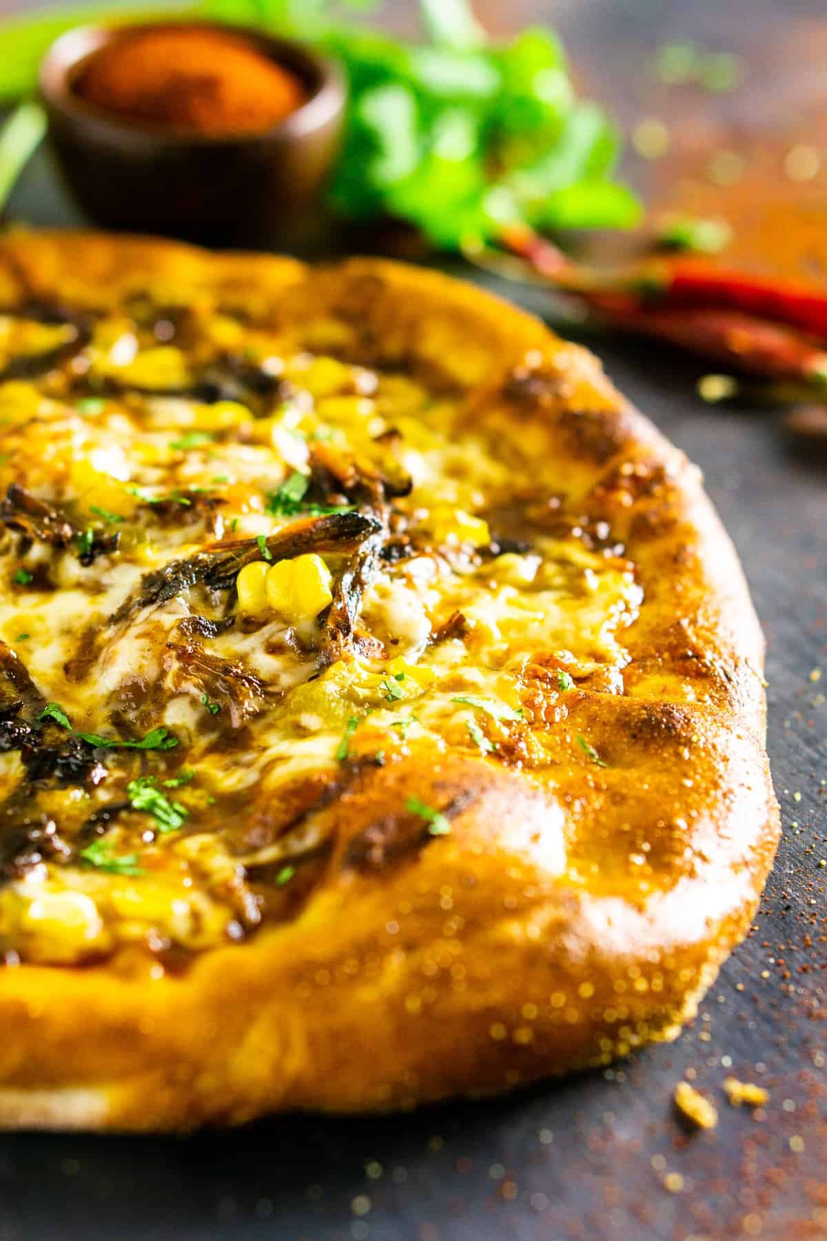 A closeup of the Mexican beef pizza with cilantro and chile powder.