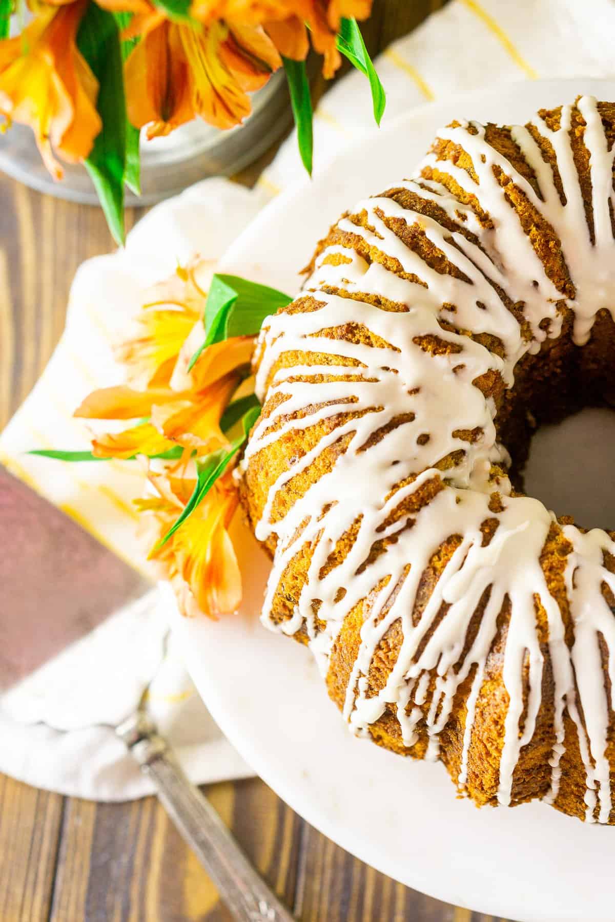 An aerial view of the carrot pound cake with a cake server on the side on a yellow and white napkin.