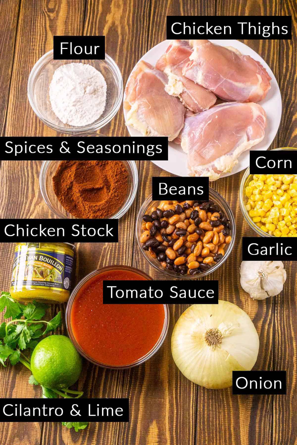 The instant pot chicken enchilada soup ingredients with black and white labels on a wooden board.