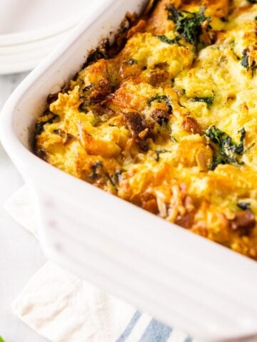A pan of cooked bacon, Gruyere and spinach strata on a napkin.