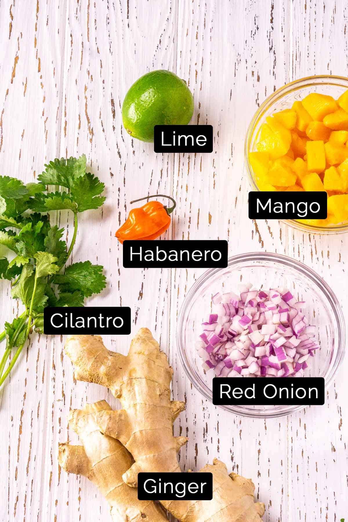 The ingredients with labels on a white wooden board.