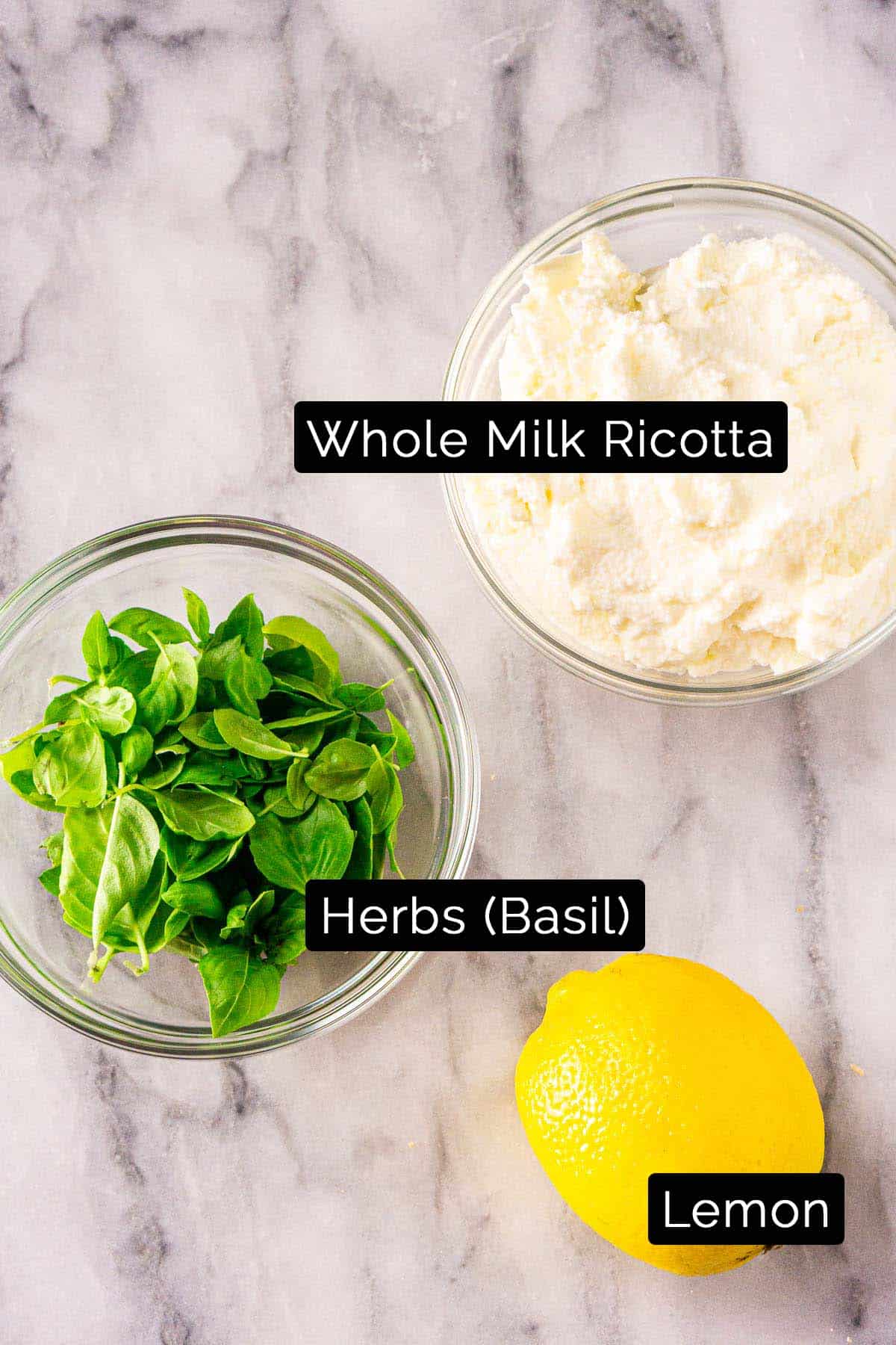 The whipped ricotta ingredients with black and white labels on a marble board.