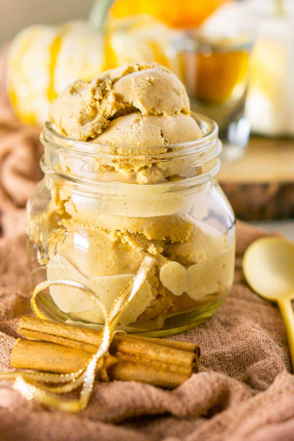A close-up of the bourbon pumpkin ice cream with a bundle of cinnamon sticks in front of it.