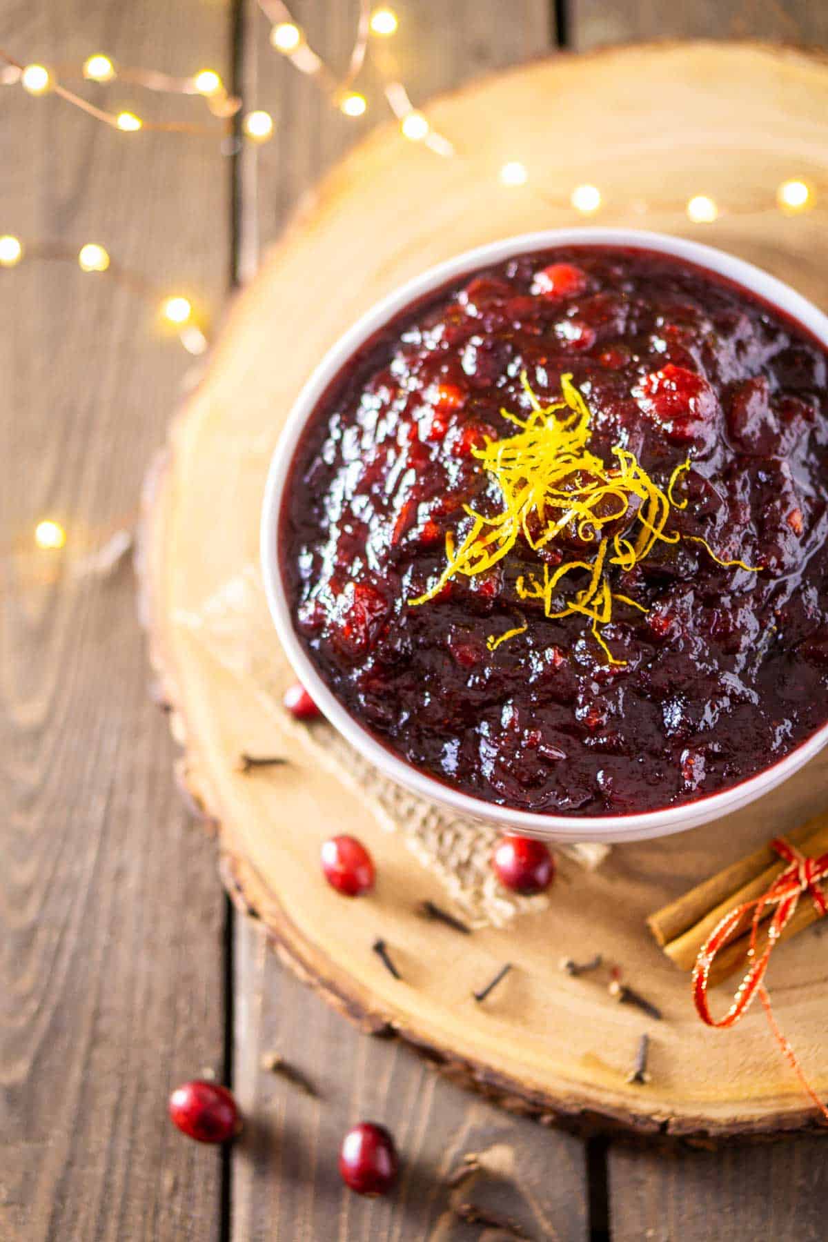 A bowl of boozy cranberry sauce with lights around it.