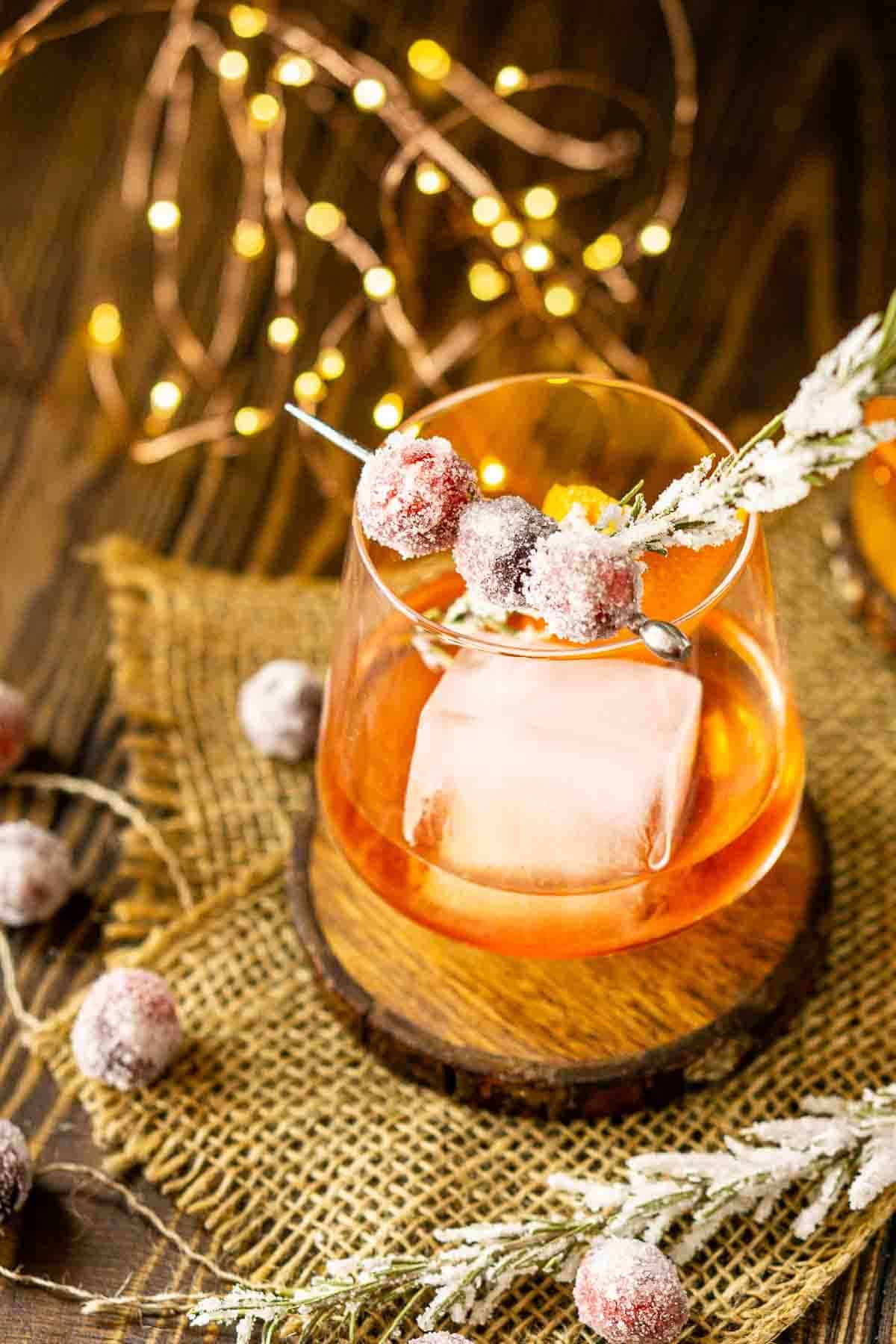 Looking down at the cocktail with the sugared cranberry and candied rosemary garnish.