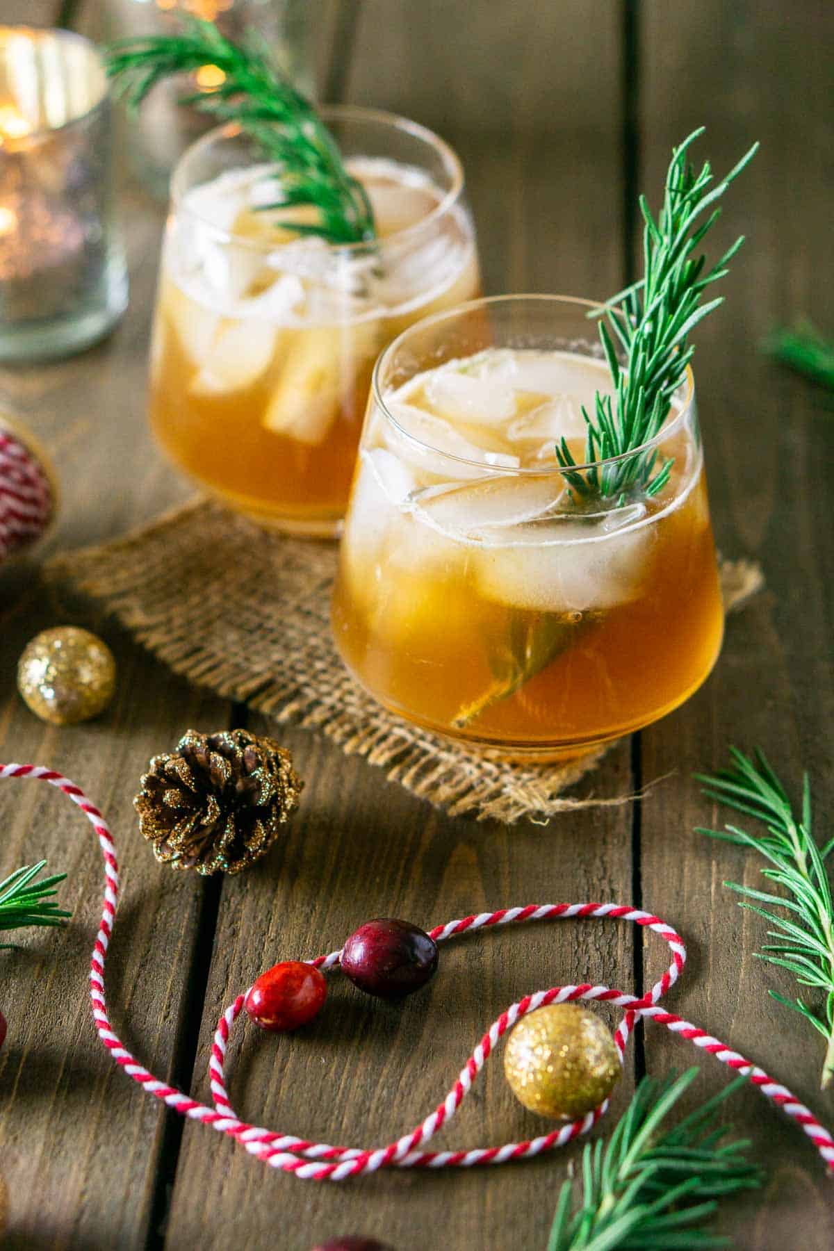 Two chai-cranberry bourbon smashes surrounded by holiday decor.