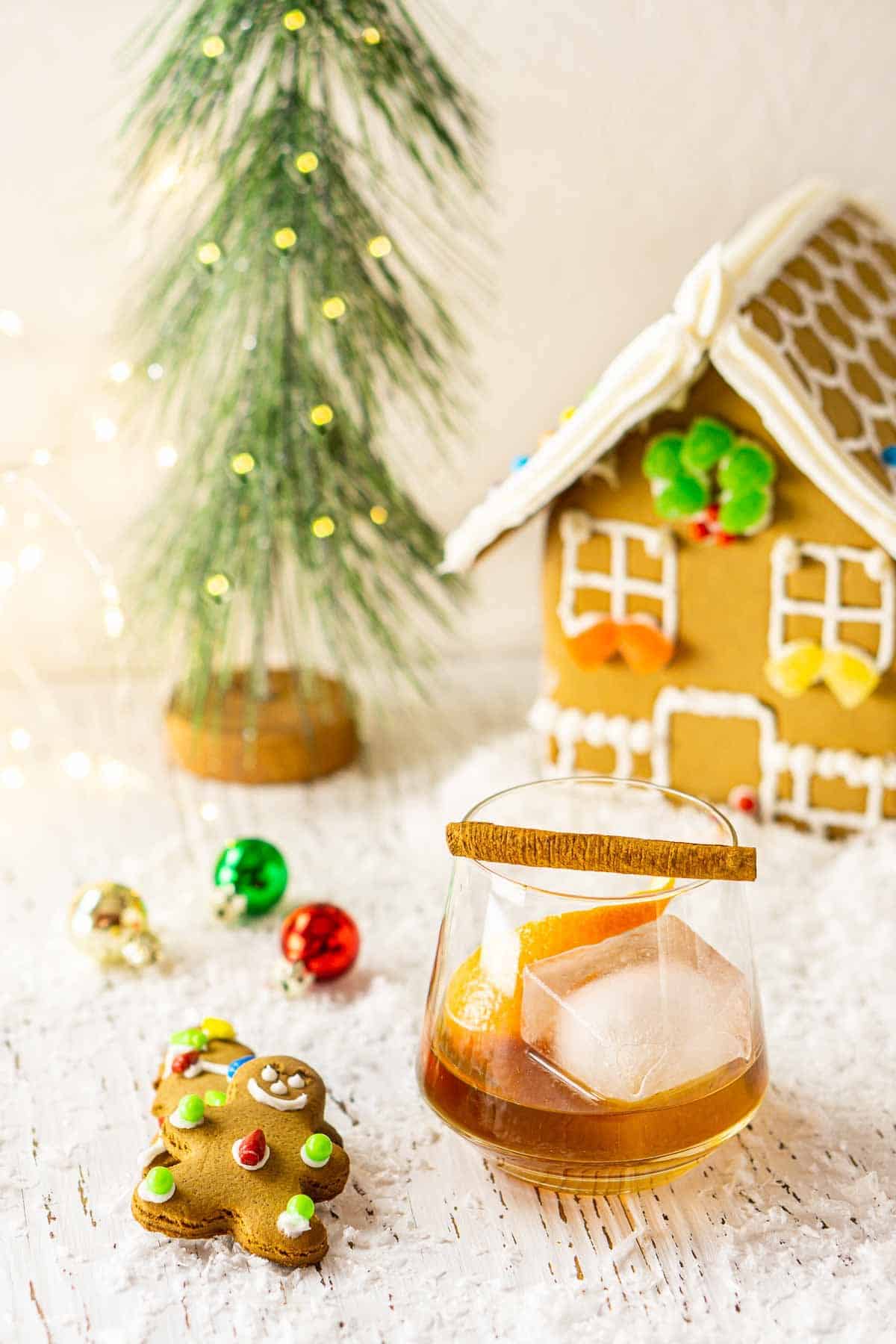 Looking down at a gingerbread old fashioned with Christmas decor and lights around it on fake snow.