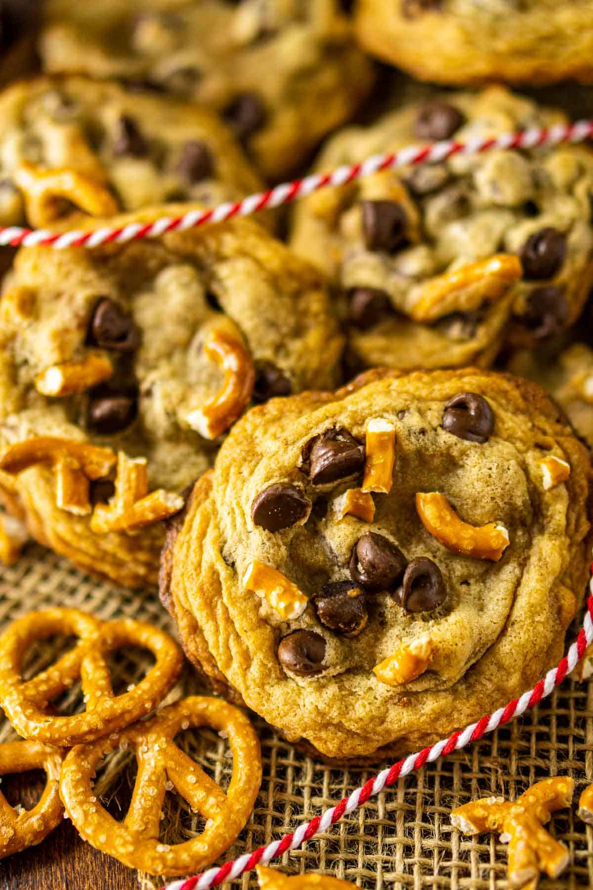 Looking down on some pretzel chocolate chip cookies on a burlap with crushed pretzels.