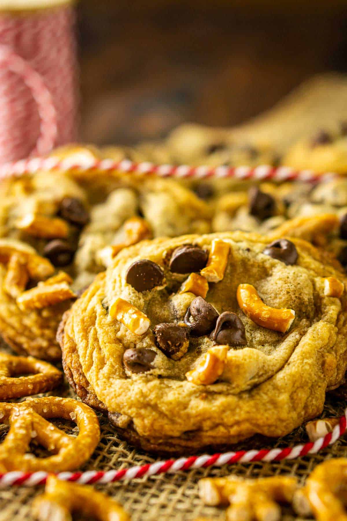 A close-up shot of a pretzel chocolate chip cookies with crushed pretzels to the side.