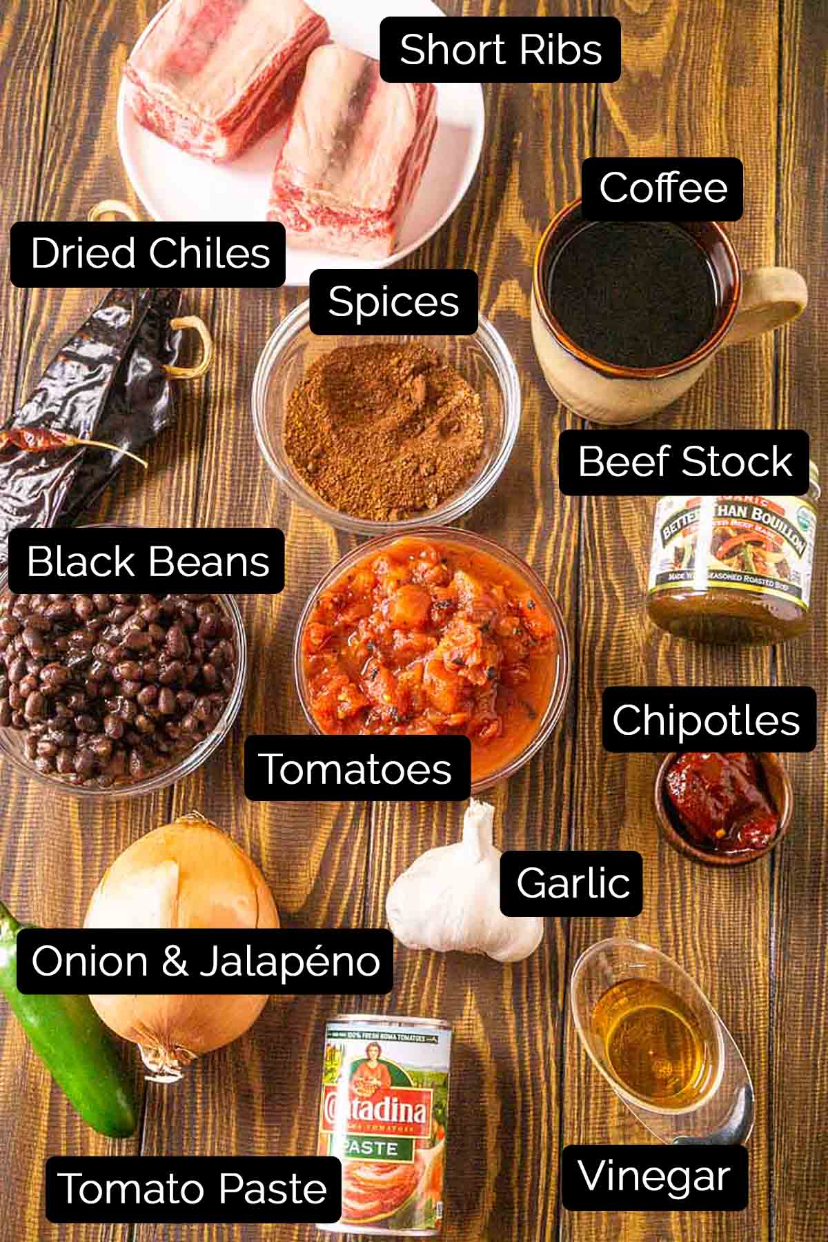 The short rib chili ingredients with black and white labels on a wooden surface.