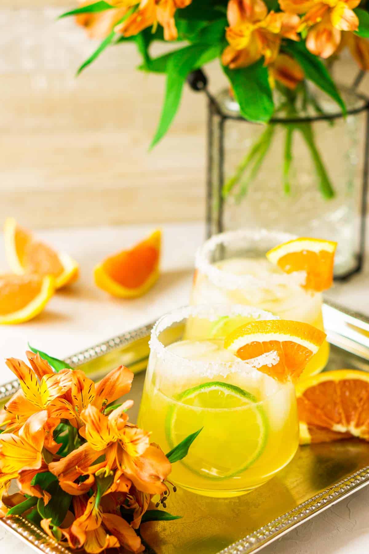 A cara cara margarita using fresh winter citrus juice with orange flowers around it.