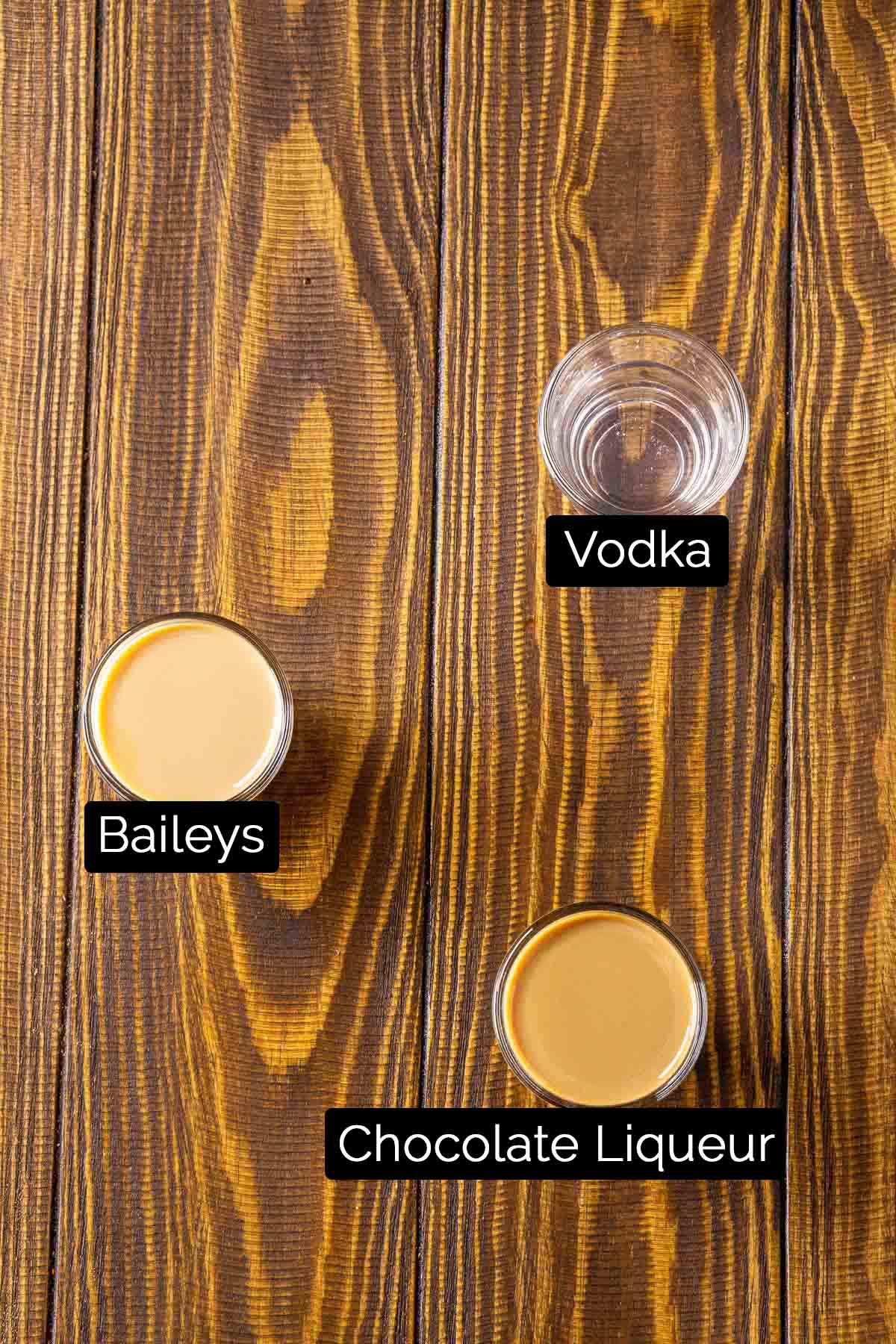 The Baileys chocolate martini ingredients with labels on a wooden board.