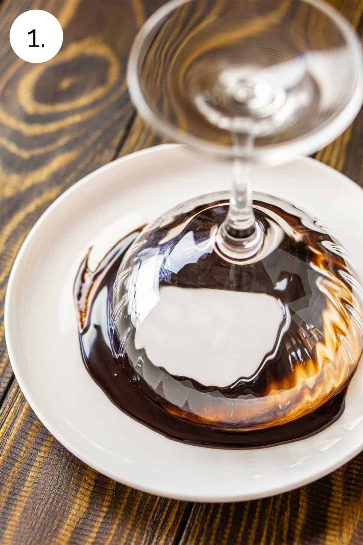 Swirling the cocktail glass in chocolate syrup on a plate.