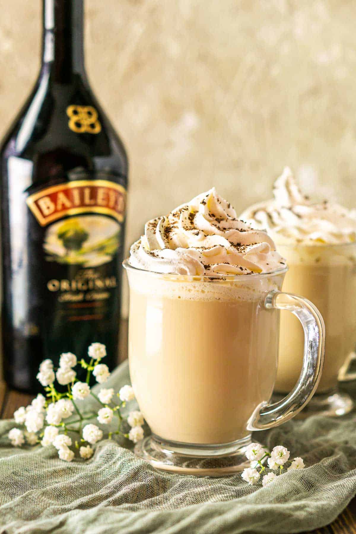 A close-up of the Baileys latte with flower and Irish cream in the background.