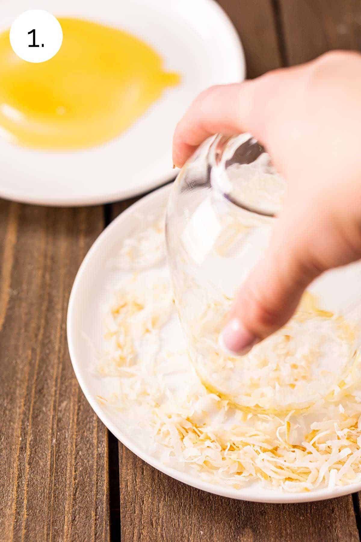 Swirling the glass in toasted coconut on a small white plate.