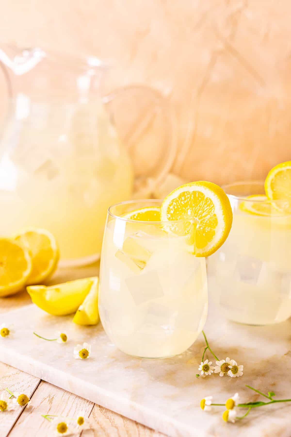 A close-up shot of the tequila lemonade with white flowers around it.