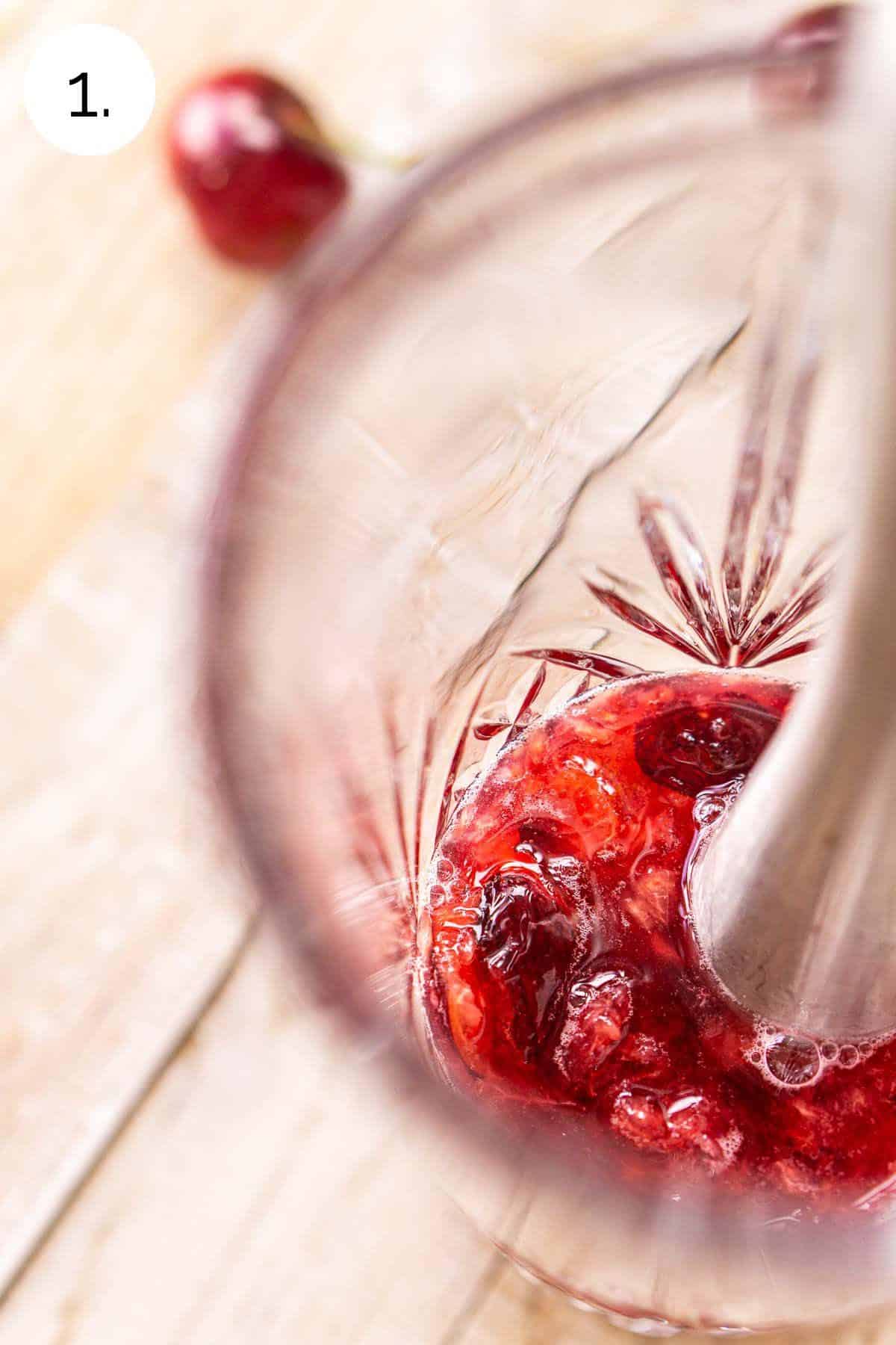 Смешайте вишни с простым сиропом, пока они не растворятся в прозрачном шейкере для коктейлей.