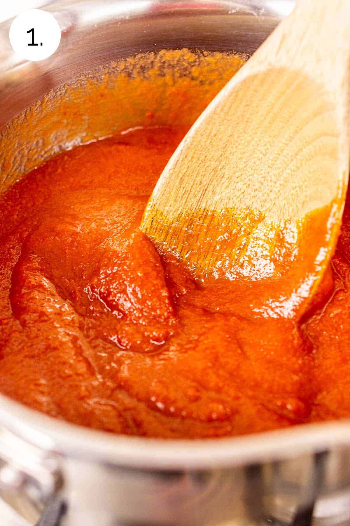 Stirring together the tomato sauce and tomato paste to make one cohesive mixture.