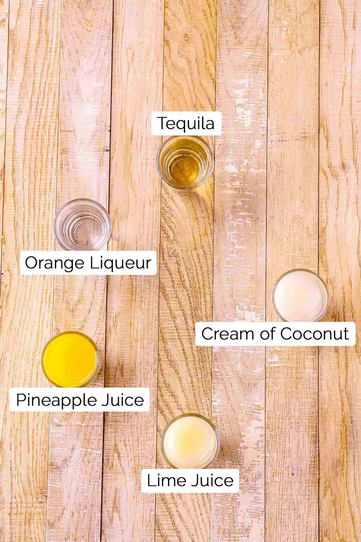 The ingredients with black and white labels on a cream-colored wooden surface.