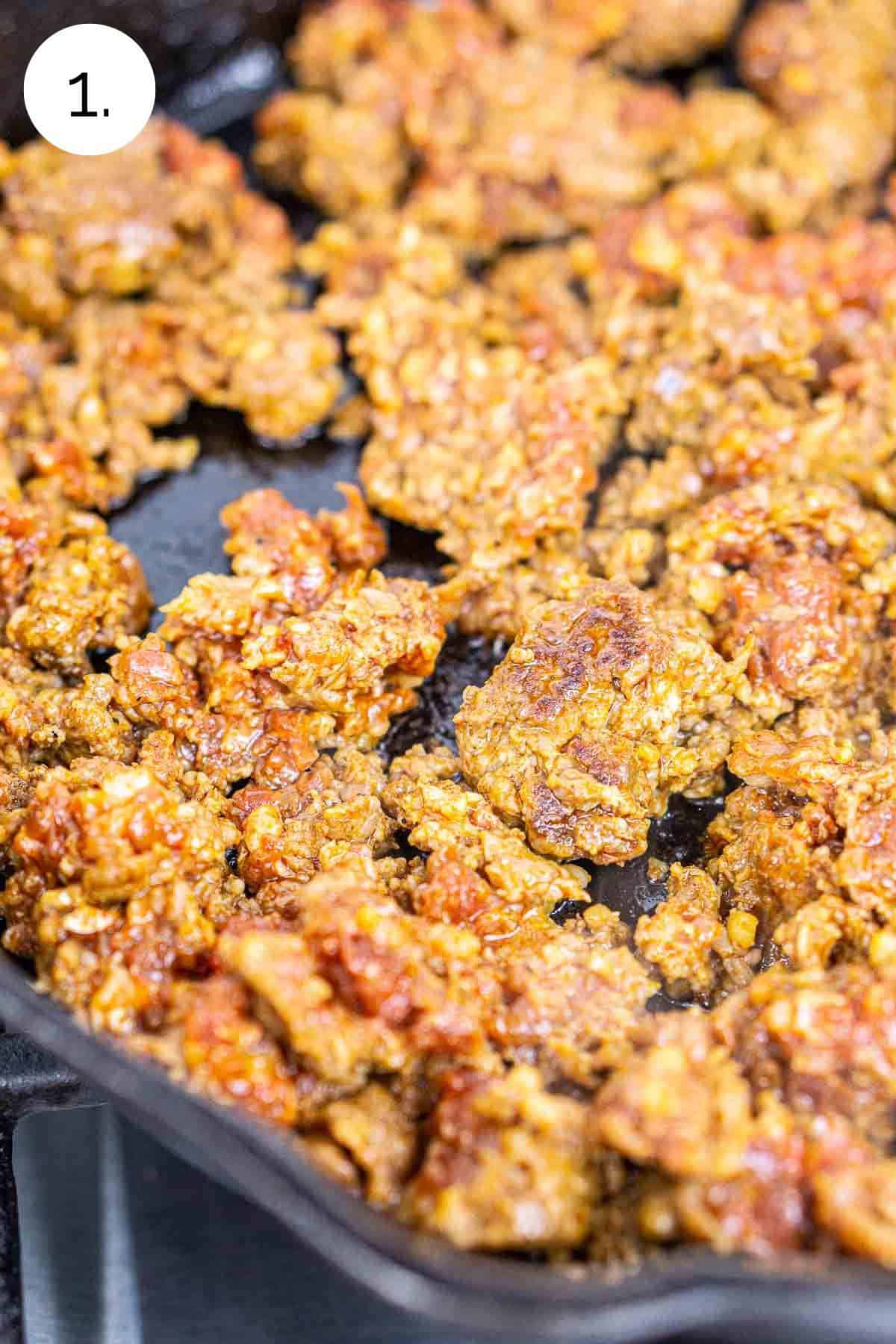 Browning the chorizo in a cast-iron skillet on the stove.