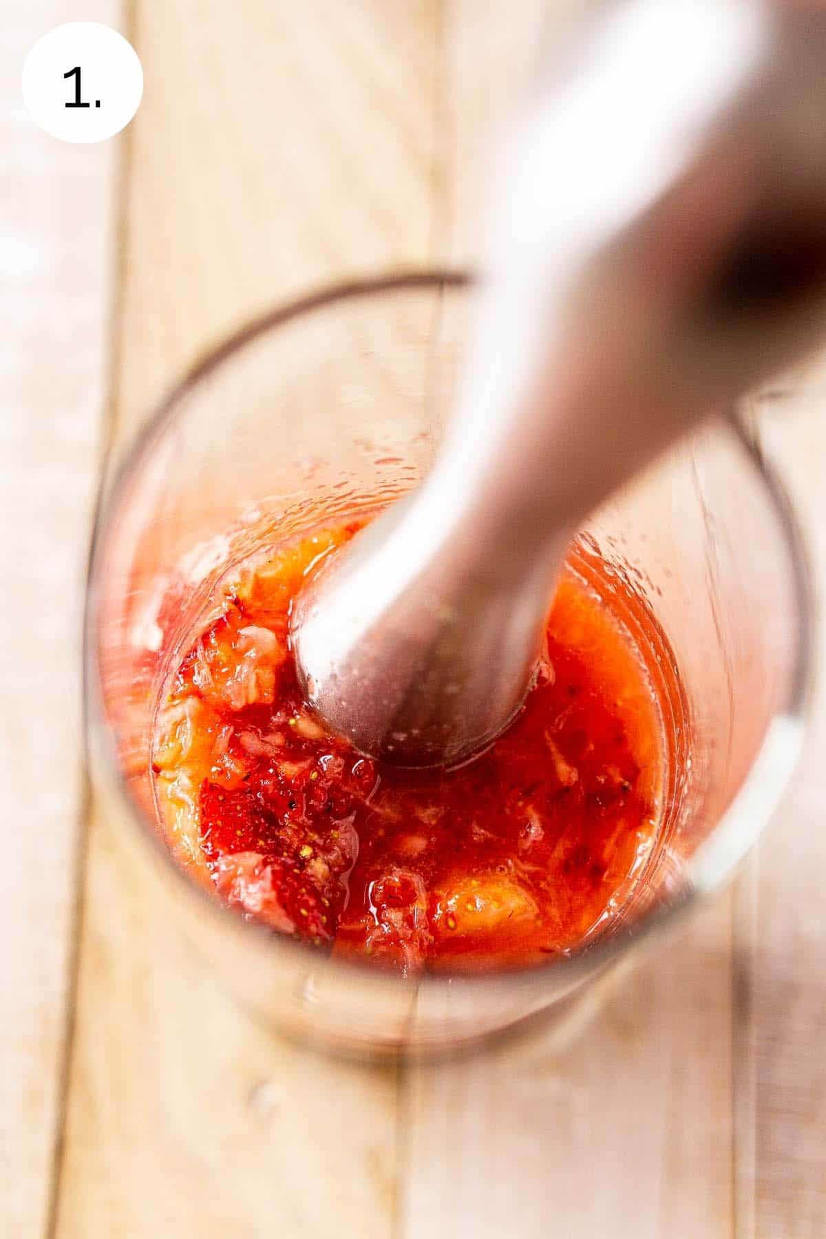 Muddling the strawberries in the highball glass until they break down and turn juicy.