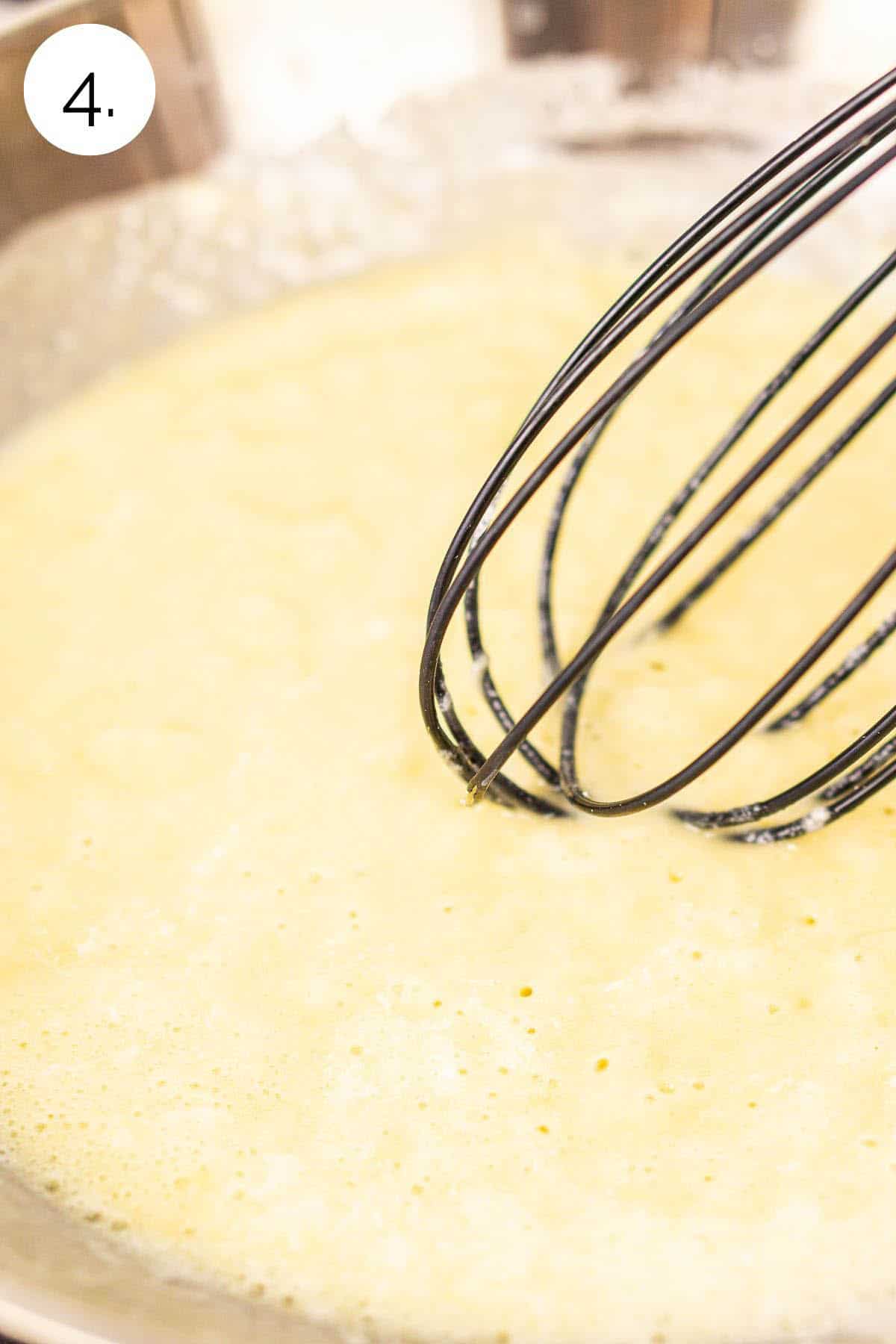 Whisking the butter, garlic and flour in a skillet on the stove to make the early stage of the roux.