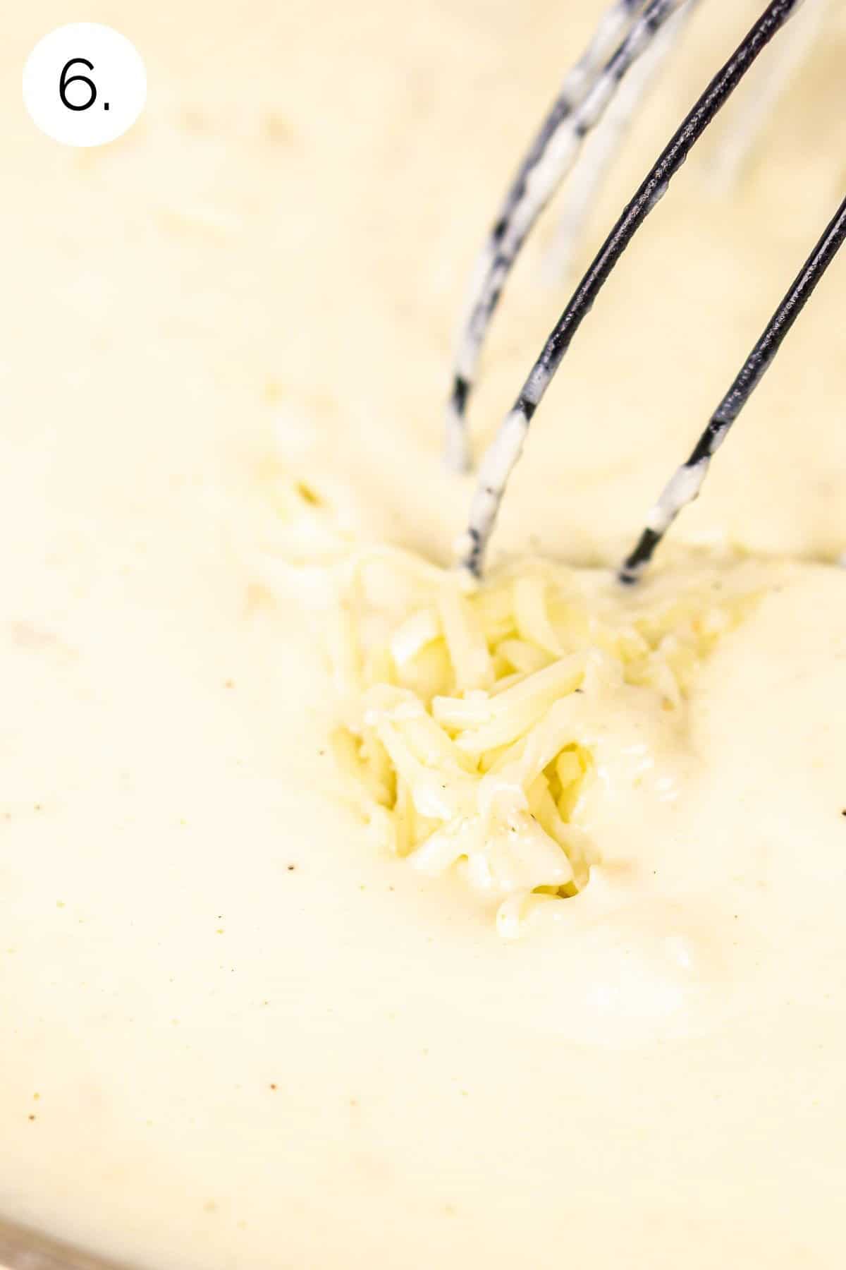 Stirring in the grated cheese into the cream mixture until it's almost melted on the stove.