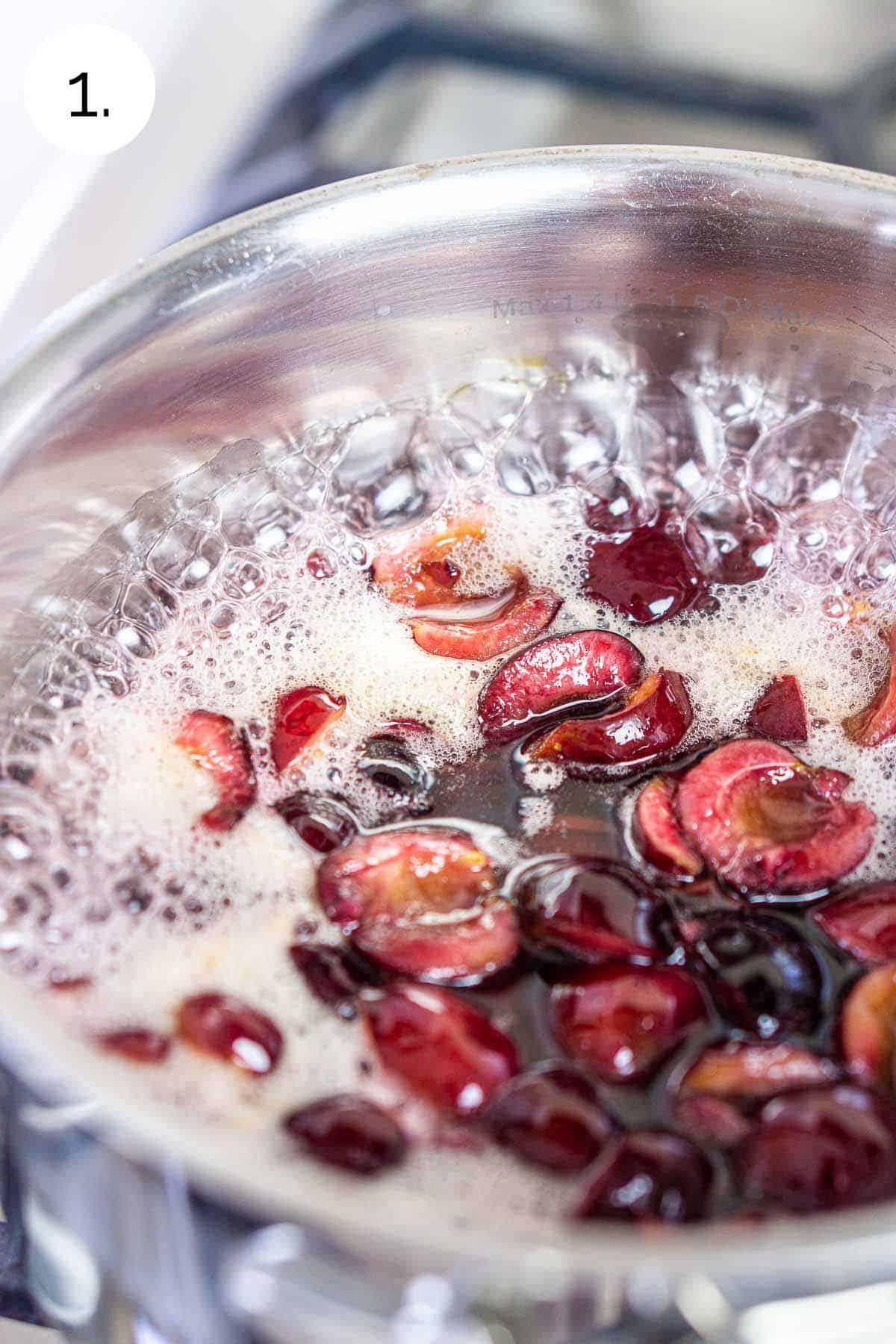 Boiling the sugar, water and cherries in a small saucepan on a stove-top range.