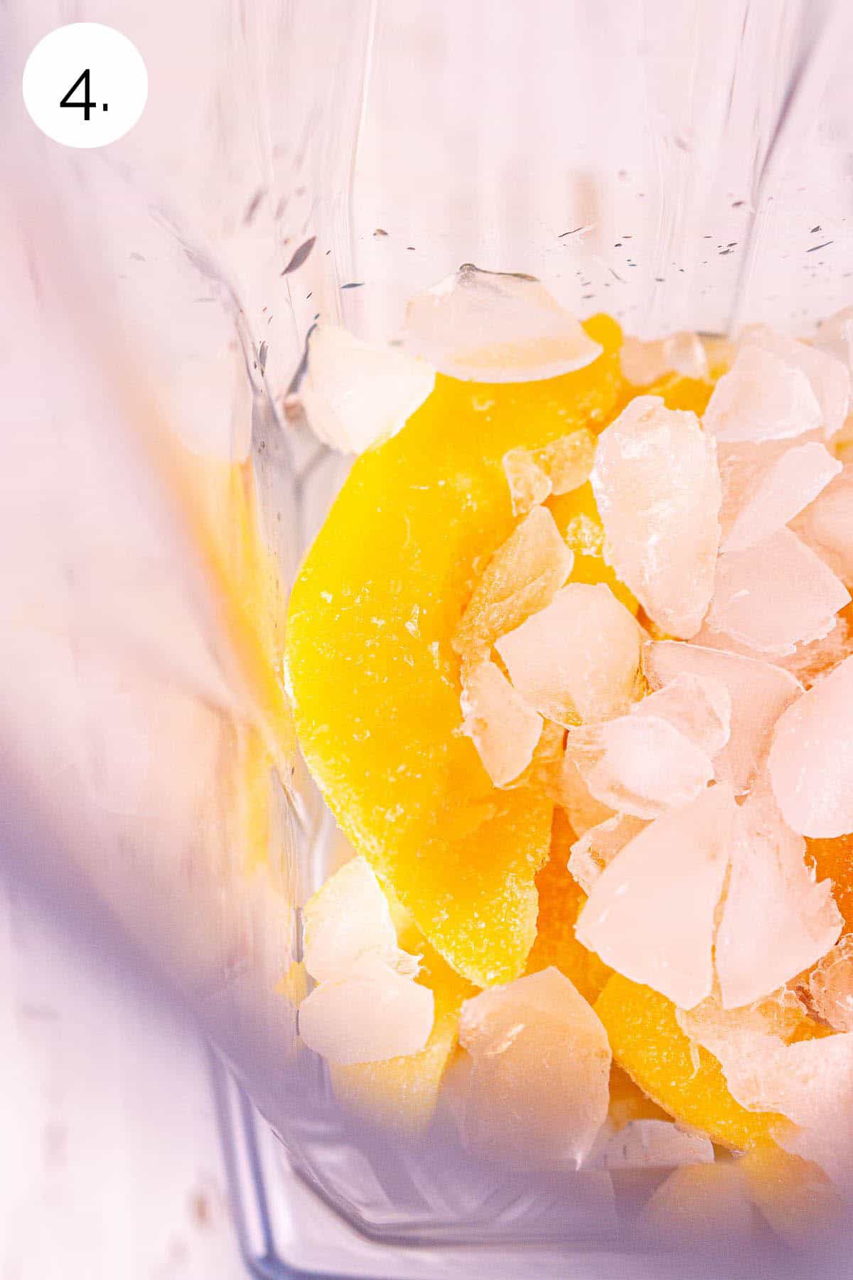 The frozen ingredients in a blender on a white wooden surface before processing until smooth.