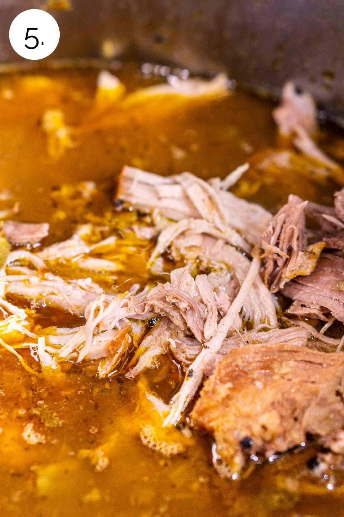 The pork after it's been shredded and put back into the chili in the stainless stockpot.