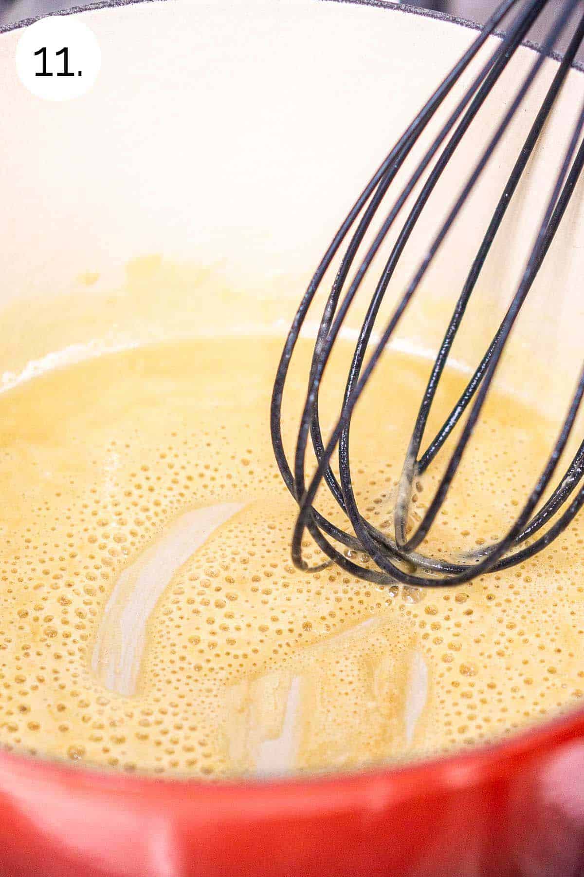 Whisking together butter and flour in a small Dutch oven on the stove to make the roux.