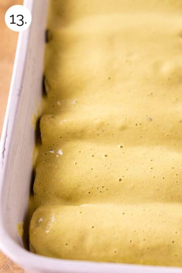The rolled enchiladas in a white baking dish with the verde sour cream sauce poured on top.