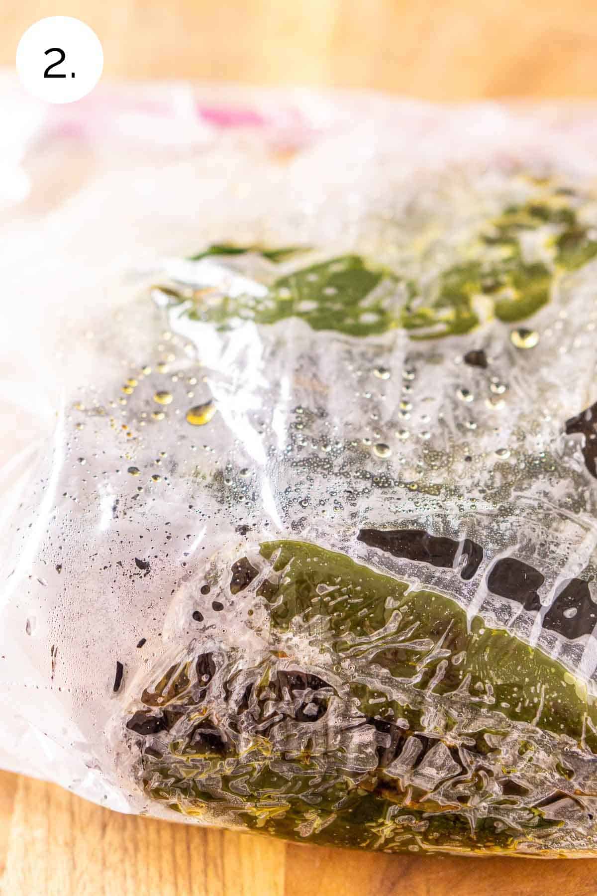 The poblano peppers in a plastic bag after broiling in the oven as the skins soften.