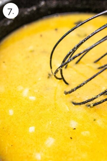 Whisking in the broth into the roux to make the liquid base of the sauce.