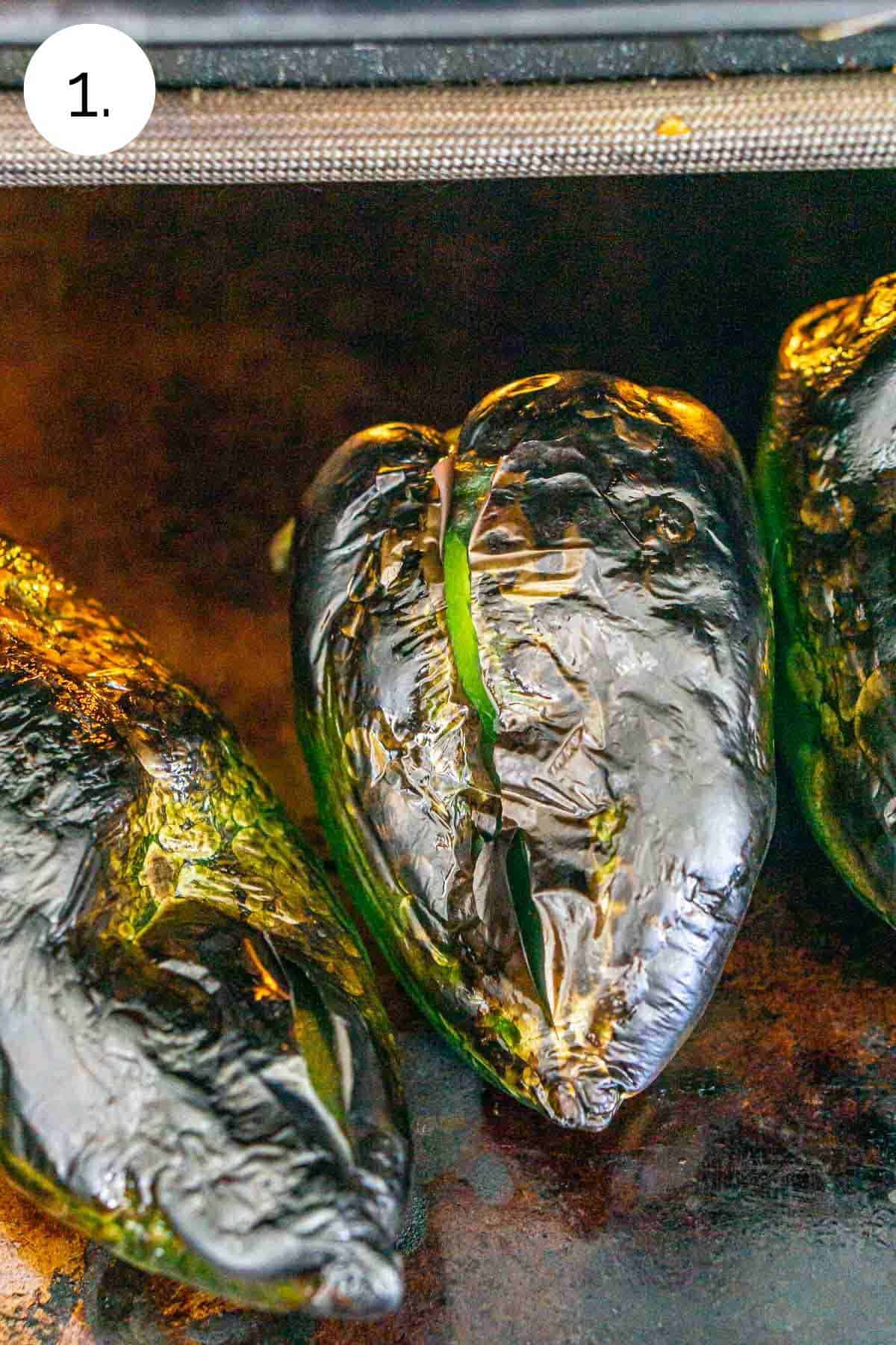 The peppers on a baking dish after they've broiled until all sides are black.