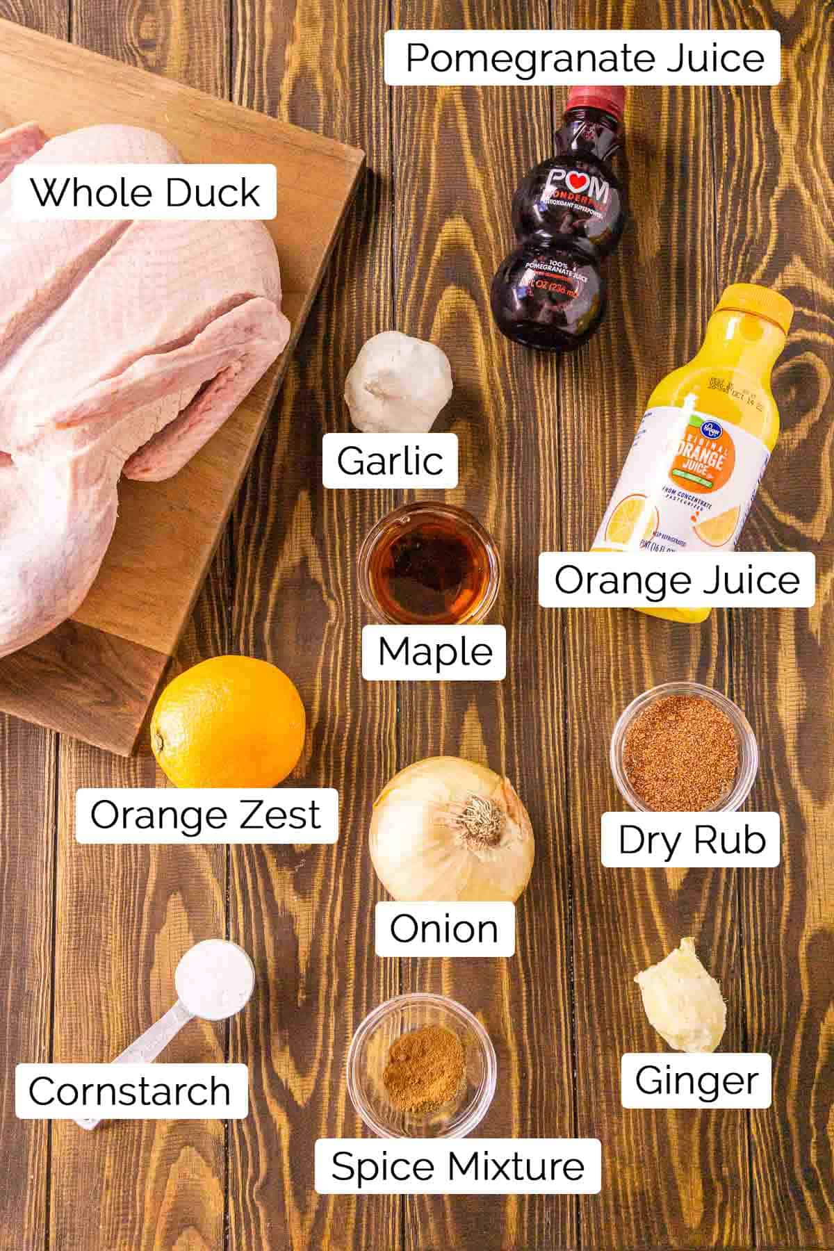 The ingredients on a wooden surface with black and white labels by each item.