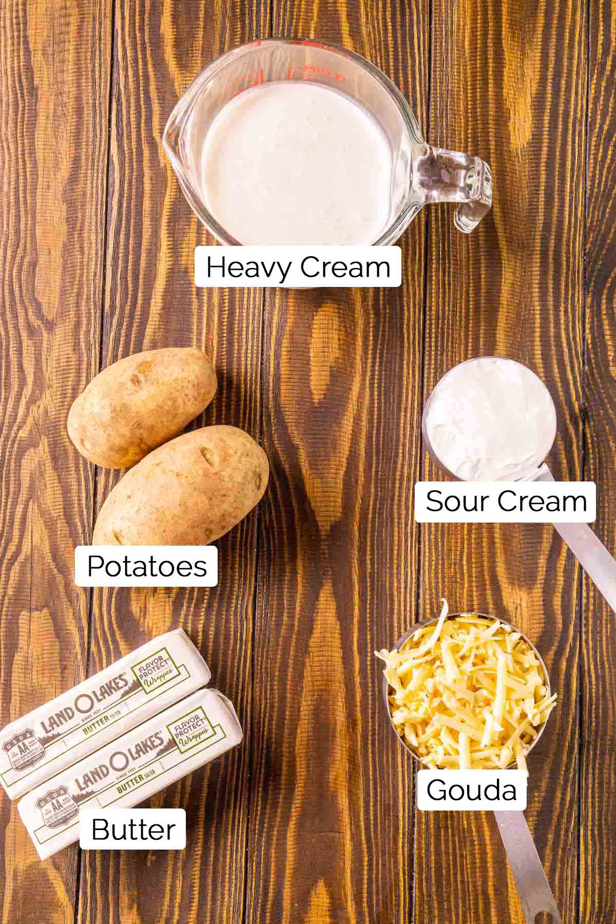 The ingredients on a wooden surface with black and white labels by each food item.