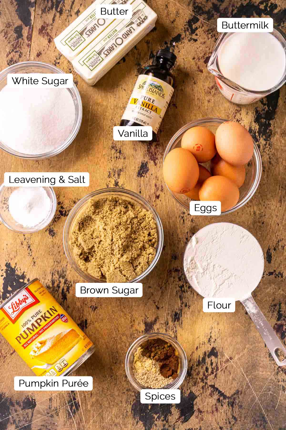 The cake ingredients on a wooden board with black and white labels by each item.