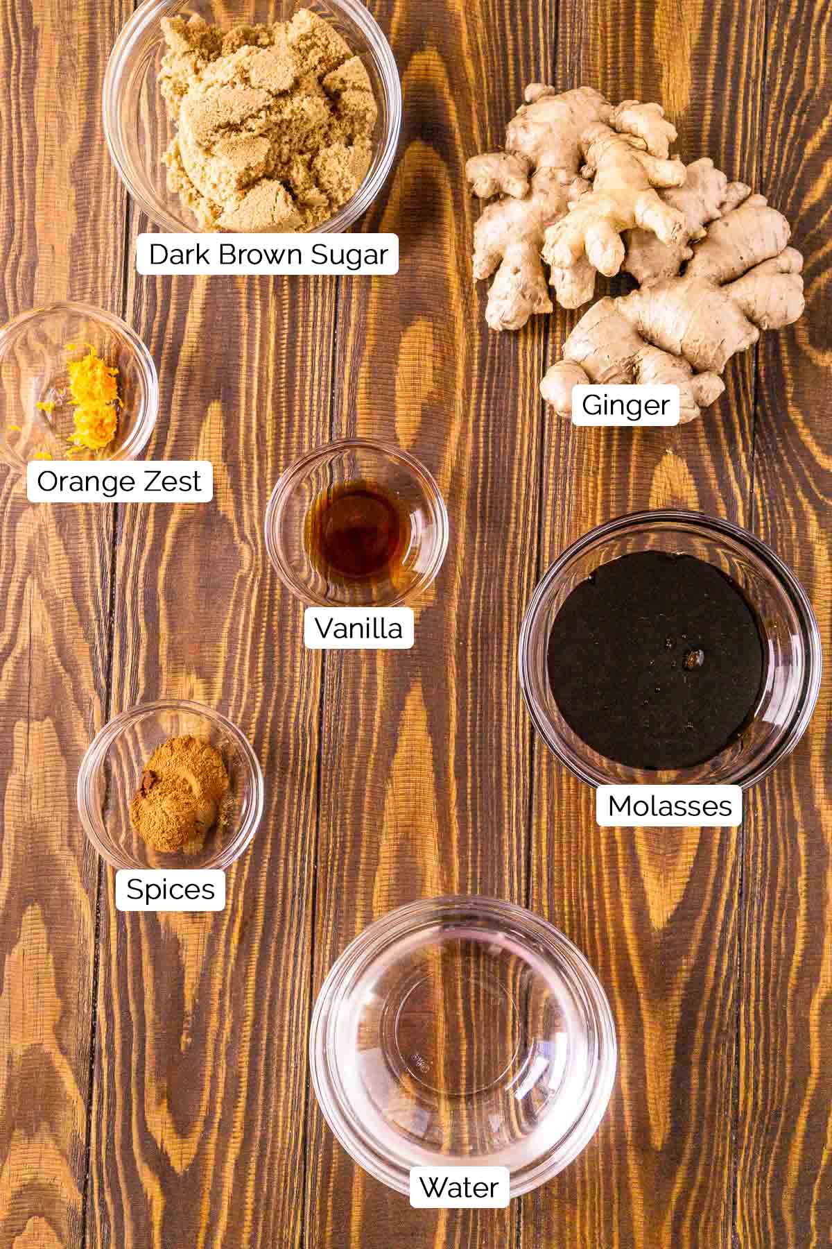 The ingredients on a brown wooden surface with black and white labels underneath each item.