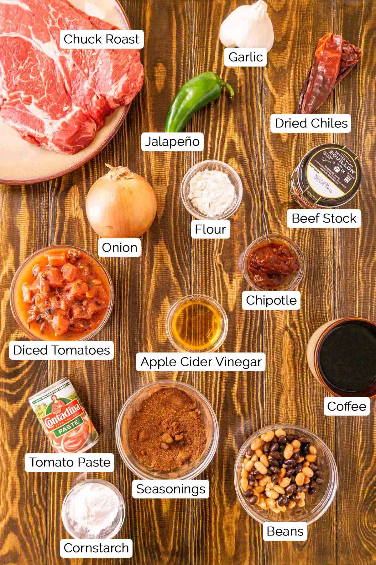 The ingredients on a brown wooden surface with white and black labels with each item.