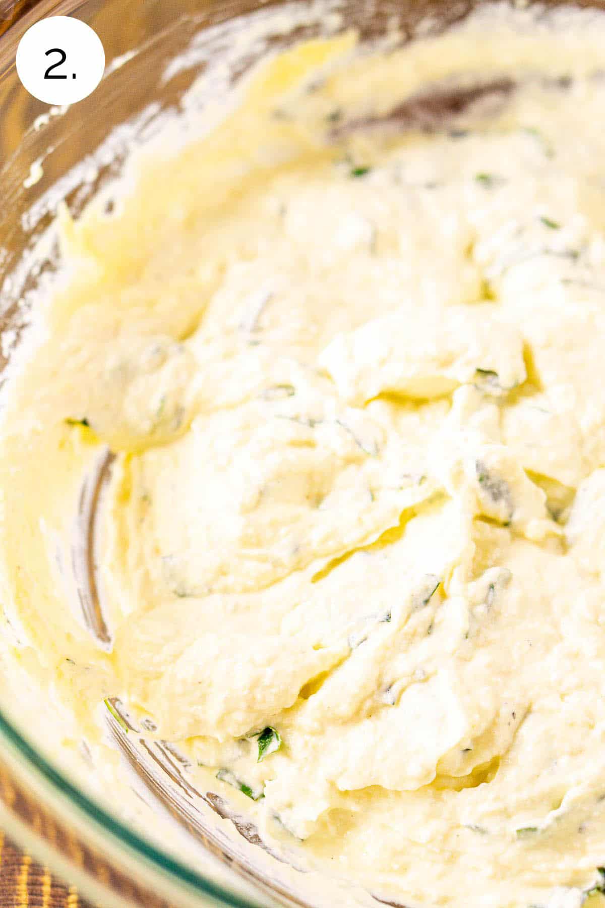 The ricotta filling stirred together to make one cohesive mixture in a large glass mixing bowl.
