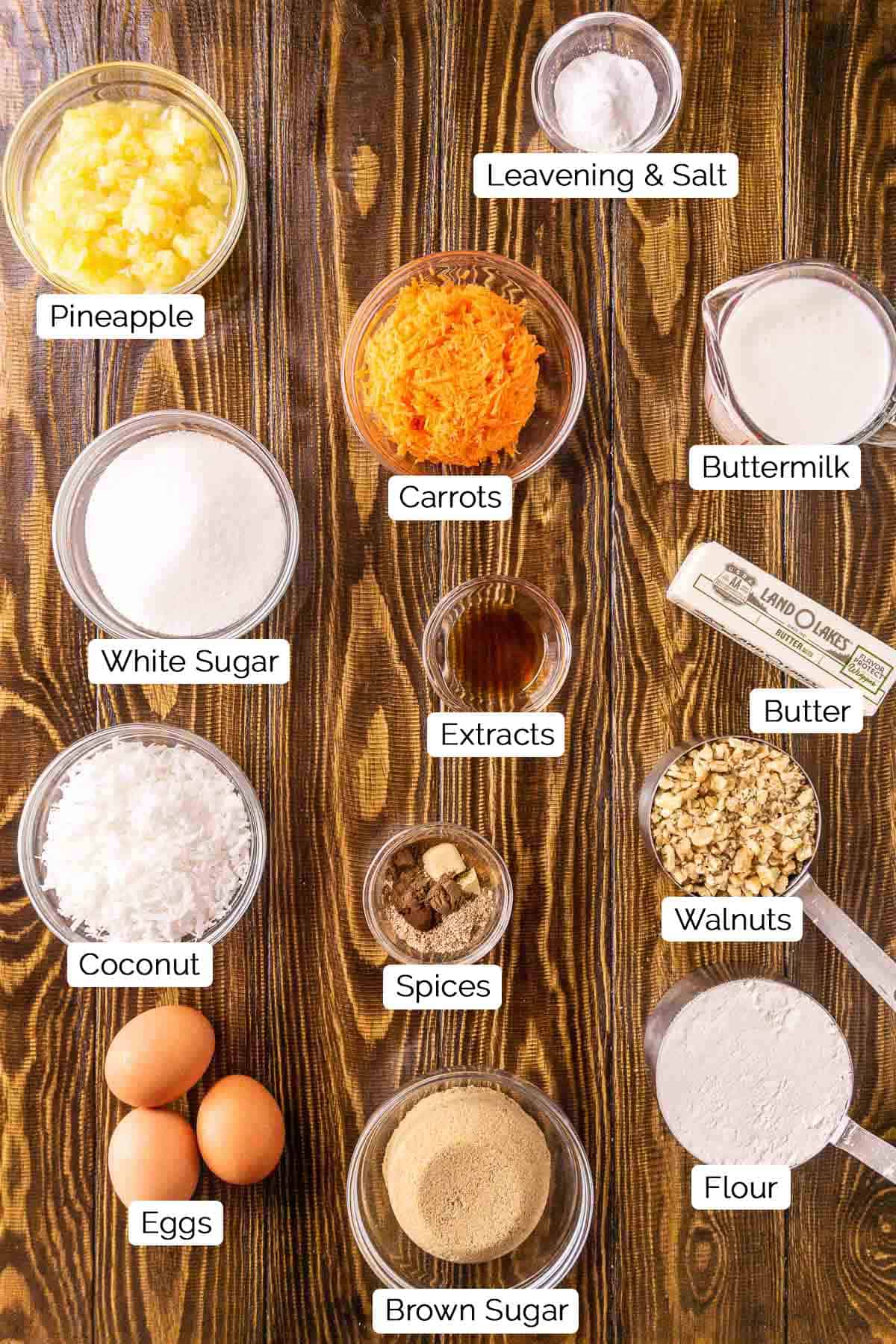 The cake ingredients on a brown wooden board with black and white labels underneath all the items.